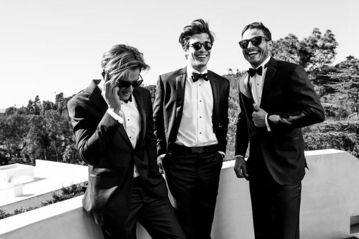 The Black Tux groomsmen laughing in tailored tuxedos